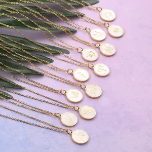 Macro detail of golden zodiac necklaces with white mother of pearl inlay on purple background