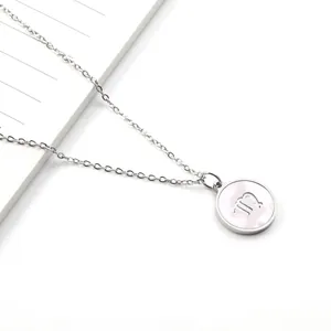 Detail of silver Virgo zodiac necklace with a white mother of pearl round pendant