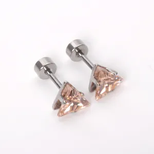 Macro-opname van driehoekige champagne zirkonia oorknopjes met zilverkleurige zetting