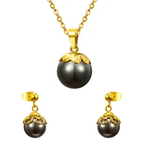 Conjunto de joyas doradas con collar de perlas negras y pendientes con diseño calado