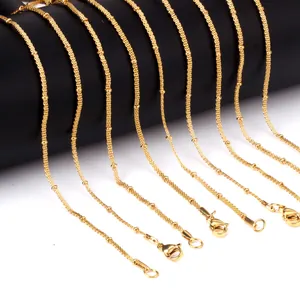 Detailopname van 2 mm gouden roestvrijstalen gaaskettingen met kralen en sluitingen