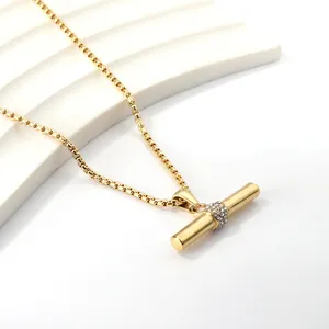 Gouden roestvrijstalen ketting met cilinder hanger en zirkoon op geometrische standaard
