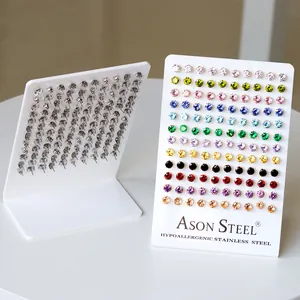 Colorful round zirconia stud earrings set in stainless steel on white display stand
