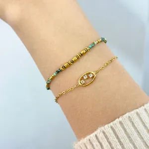 Detail of bohemian gold link chain with crystal oval and turquoise beaded bracelet set