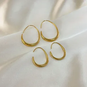 Minimalist 18K gold plated hollow teardrop earrings on white silk fabric background