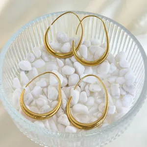 Chic 18K gold plated hollow teardrop earrings displayed on white pebbles in a glass bowl