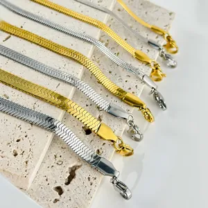 Catene a serpente piatte lucide oro e argento su pietra con chiusura a moschettone