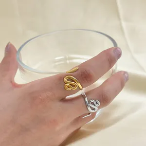 Dettaglio di anelli a forma di serpente oro e argento sulla mano della modella