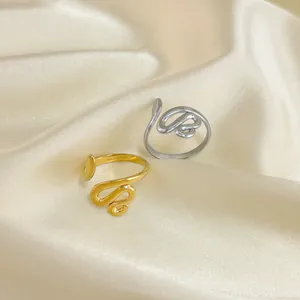 Anelli minimalisti a forma di serpente in oro e argento su tessuto di seta lucido