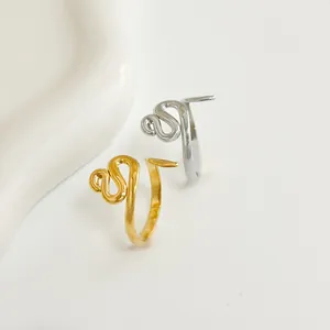 Dettaglio di anelli a serpente minimalisti in oro e argento con design aperto regolabile