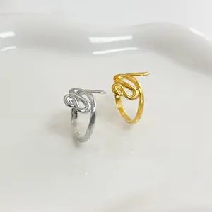 Dettaglio degli anelli a serpente argento e oro su un vassoio espositivo in ceramica