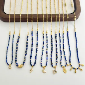 Lapis lazuli beaded necklace set with gold pendants like moon, snake, and leaf charms