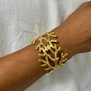 Vue détaillée d'un bracelet branche martelé doré avec texture corail porté au poignet