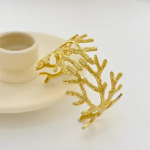 Détail d'un bracelet doré style branche texturée sur un support en céramique
