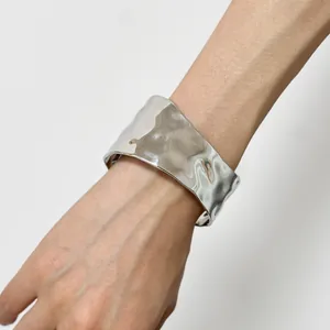 Minimalist wide cuff bracelet in silver finish with irregular hammer texture and open design