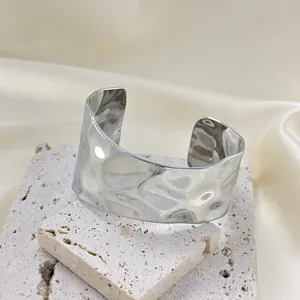 Minimalist silver stainless steel cuff bracelet featuring a textured hammered finish