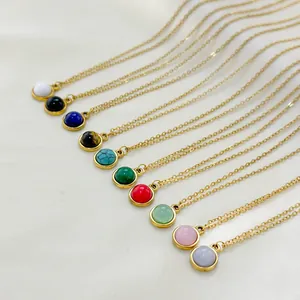 Golden round pendant necklaces with various natural stones displayed on silk fabric