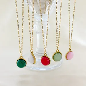 Set of five round natural stone pendant necklaces with gold chains on glass edge