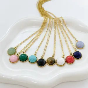 Detailed overhead view of ten colorful round natural stone pendants with gold chains on a tray