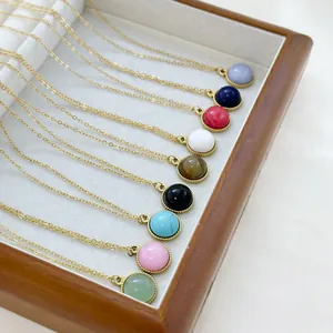 Set of nine round natural stone pendant necklaces with gold chains in a wooden box
