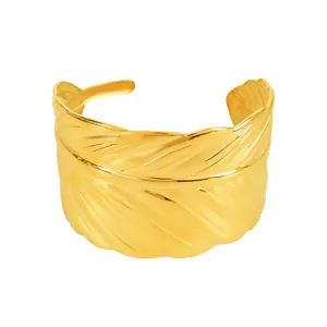 Retro golden feather-shaped open cuff bracelet with detailed texture on white background