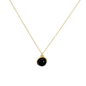 Minimalist necklace with a round black natural stone pendant on a gold chain