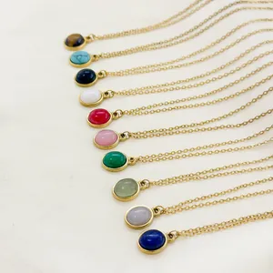 Close-up of various 18K gold necklaces featuring colorful natural stone pendants and bezels