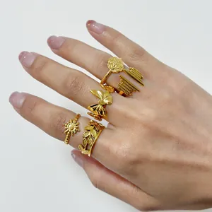 Close-up of five gold plated titanium steel rings with floral and geometric designs