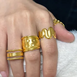 Detailansicht goldener Ringe im Set mit Wellenform, Hammerschlag und Kettenmuster für Damen