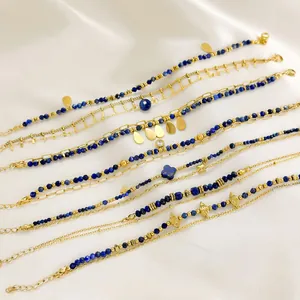 Detail von Lapislazuli-Perlen und vergoldeten Edelstahlketten auf weißer Seide