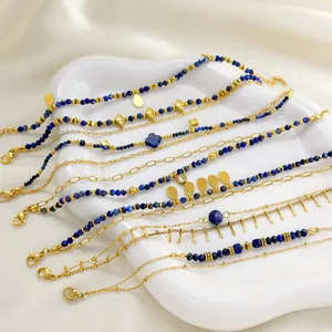 Lapis-Lazuli-Schmuckkollektion aus vergoldetem Edelstahl auf einer weißen Keramikschale