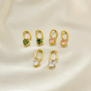 Detail view of heart-shaped zircon earrings in green, pink, and clear tones on silk