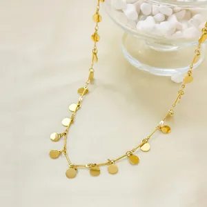 Elegant gold polished disc necklace for women on silk background, minimalist fashion jewelry