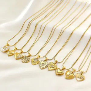 Collection of gold heart pendant necklaces with crystals on white silk background