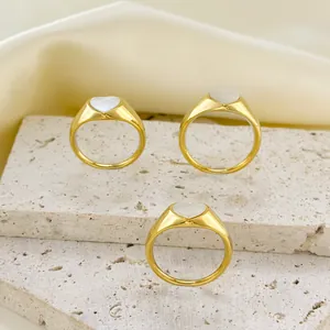 Three elegant 18k gold plated stainless steel heart signet rings on a stone stand