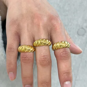 Macro shot of gold croissant style twisted ring with high polished metallic texture