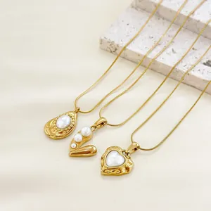 Detailed view of three gold heart and pearl pendants on elegant snake chains