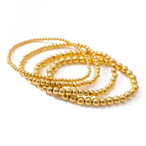 Set of four stacked minimalist golden beaded bracelets made of stainless steel for women