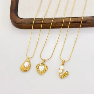 Close-up of heart and oval pearl pendants on 18k gold snake chains in a group display