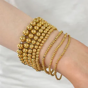 Detailed view of layered gold stainless steel bead bracelets with a metallic mirror finish