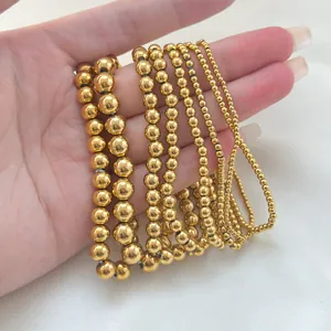 Set of gold beaded elastic bracelets in various sizes from 3mm to 8mm for layering