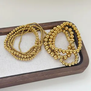 Detailed view of polished golden stainless steel beads in three different sizes for layering