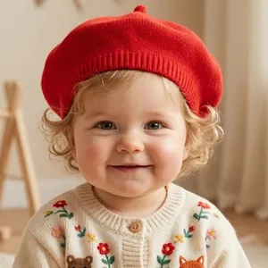 Detail of red knit baby beret with top pom and ribbed edge for infants