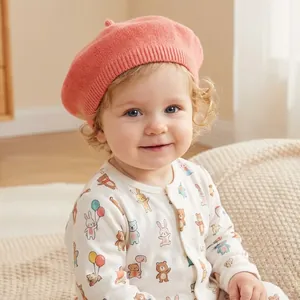 Detailed knit texture of coral pink baby beret with elastic ribbed edge for a secure fit