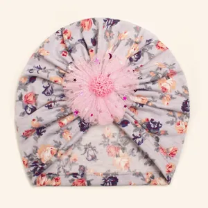 Close-up of pink mesh flower detail and floral print on gray cotton baby turban