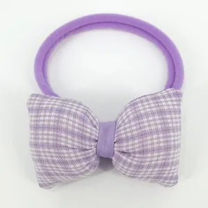 Close-up of purple plaid bow hair tie with elastic nylon band for baby girls