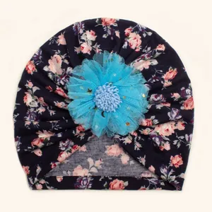 Detail of baby floral turban hat with deep blue print and large 3D mesh flower