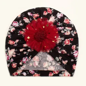 Detail of baby floral turban hat featuring red mesh flower with gold star sequins