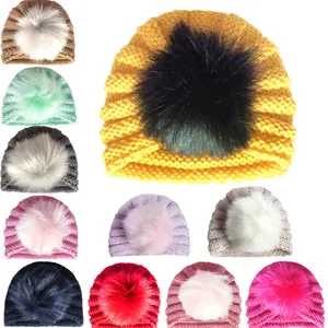 Dettaglio di vari colori per berretti in maglia calda per bambini con grandi pompon in pelliccia