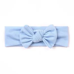 Macro detail of the light blue elastic knitted cotton baby headband with a large bow